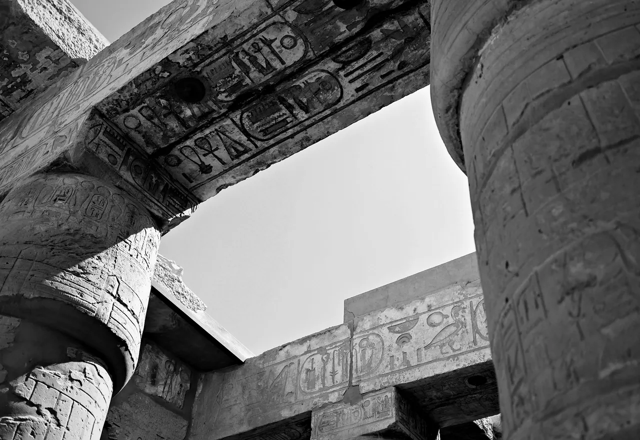 Carved stone beams meet above a passage between columns